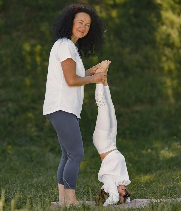 Happy child in a simple yoga pose on a colorful mat.