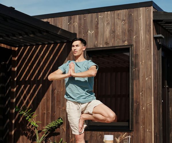 Teenager holding a tree yoga pose with focus and stability.